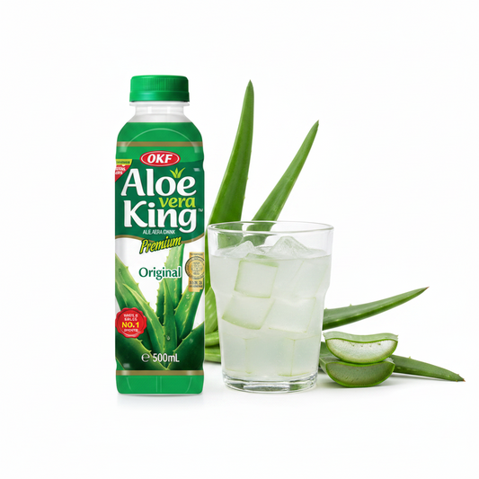 OKF Aloe Vera King Original Flasche 500 ml neben einem Glas mit Aloe-Stückchen